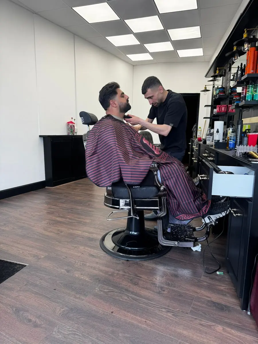 Barez trimming a customer's beard at Noah's Barber, West Wickham