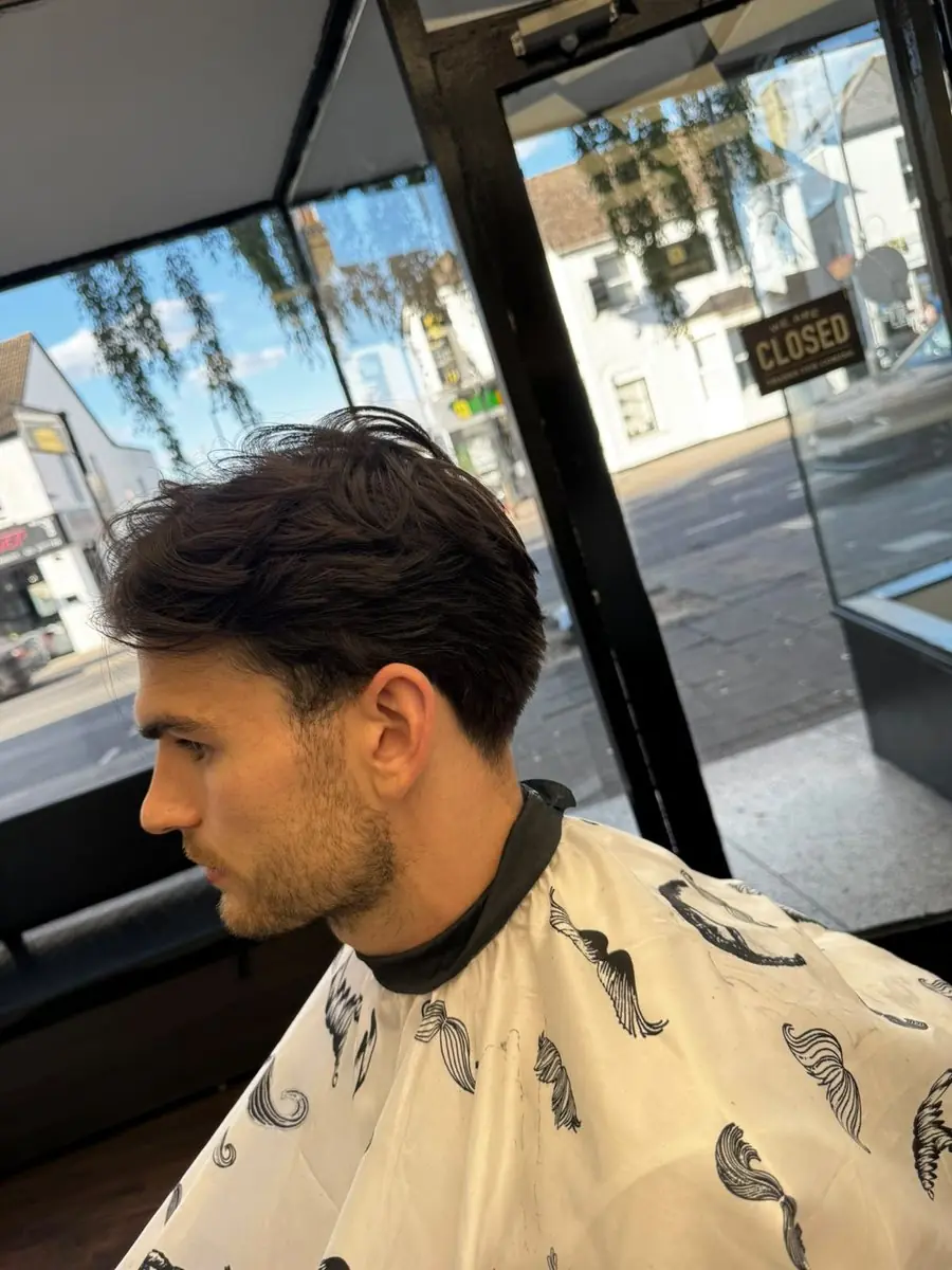 Wavy textured top pushed back with a taper at Noah's Barber